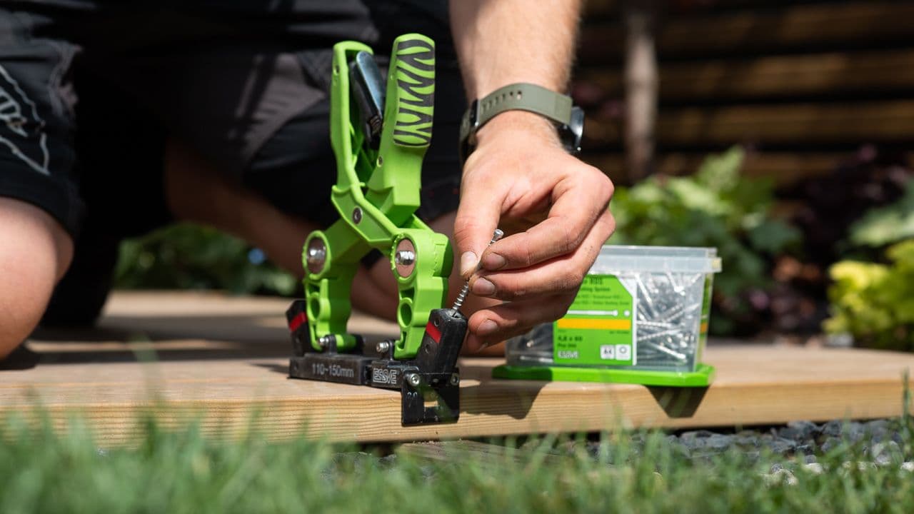 Mann som bygger terrasse med skjulte skruer.