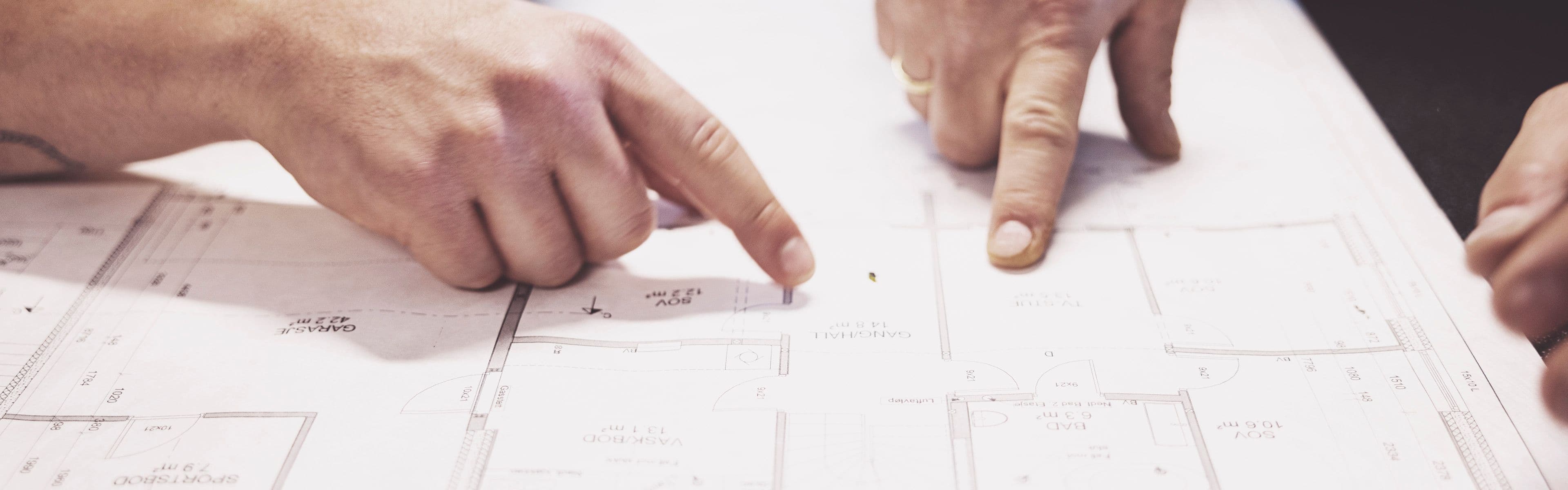 Personer som ser på plantegning og enøk-tiltak for energimerking G i bolig.