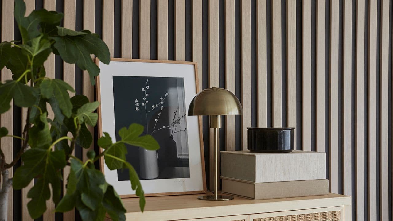 Spilevegg bak kommode med rottingfronter.