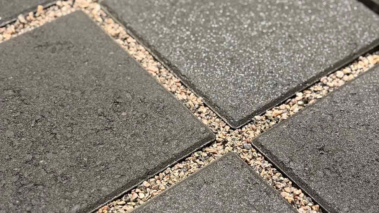 Aaltvedt Atrium belegningsstein som er lagt med store mellomrom med små dekorstein i.