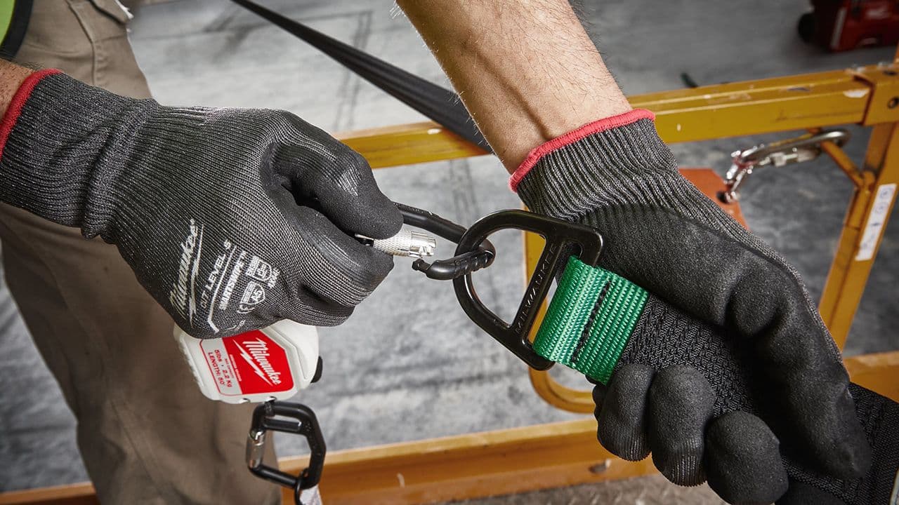 Person som hekter karabinkrok for å sikre verktøy fra fall.