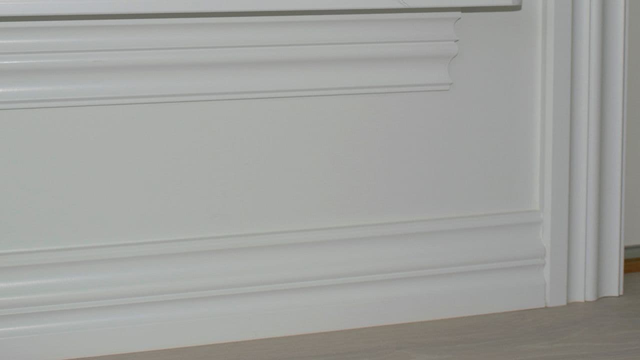 Hvitt rom med høye lister med profil.