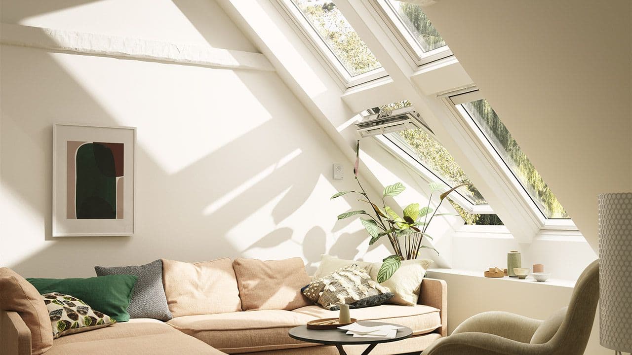 Lys stue med takvinduer i skråtak.