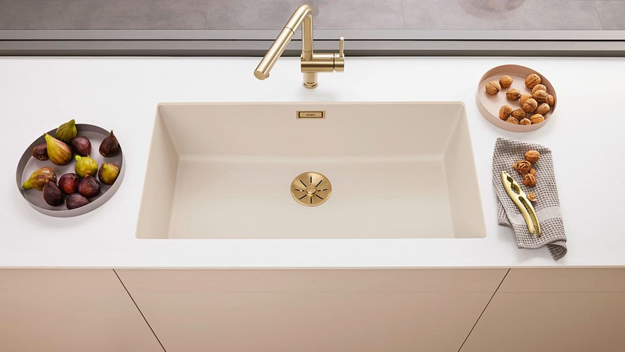 Blandebatteri i messing på lyst kjøkken.