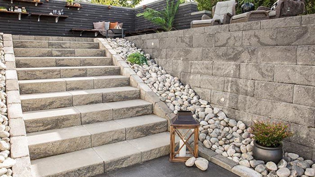 Steinmur i hage bygget med kantstein og støttemur.