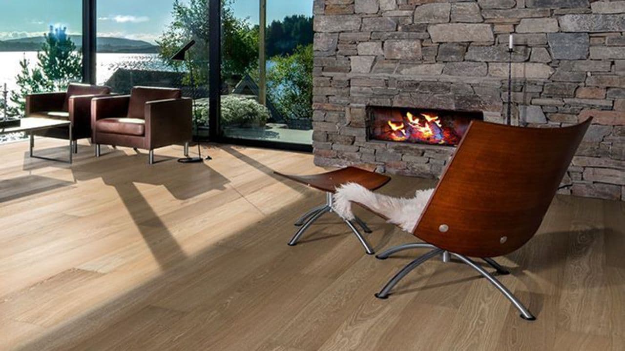 Stue med peis i naturstein og parkettgulv med naturlig varm farge.