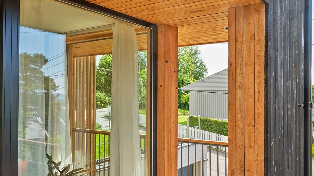 Nærbilde av MøreRoyal kledning på hus med terrasse og store vinduer.