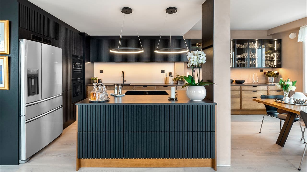 Svart kjøkken kombinert med underskap i treverk.