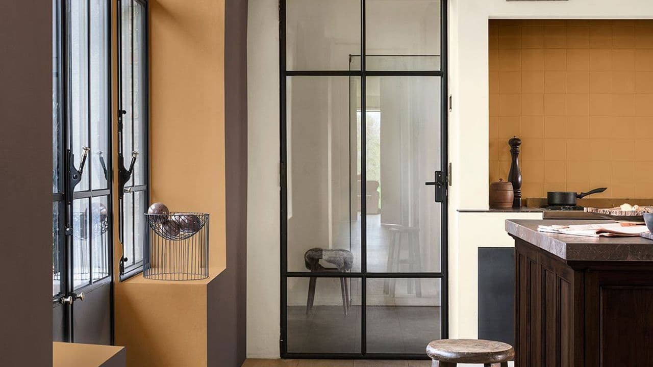 Kjøkken med glassdør og dype fargetoner av brunt og lilla.