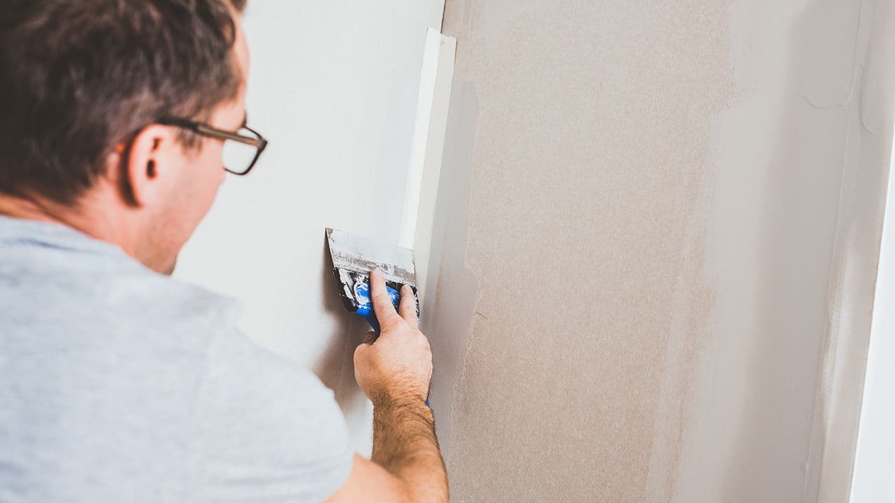 Person som sparkler hjørne ved bruk av papirremse.