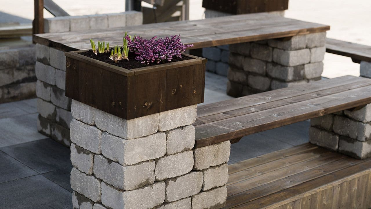 Hagemøbler bygget av belegningsstein og terrassebord.