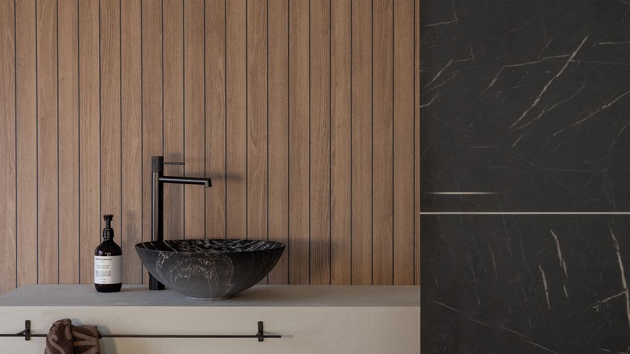 Hyttebad med smartpanel wetwall i tre- og svart marmor-design.