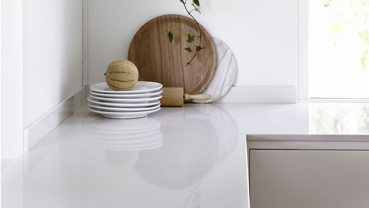 Hvite benkeplate til hvitt kjøkken.