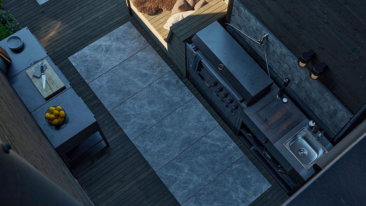 Moderne uteområde med utekjøkken og terrasse av lekter.