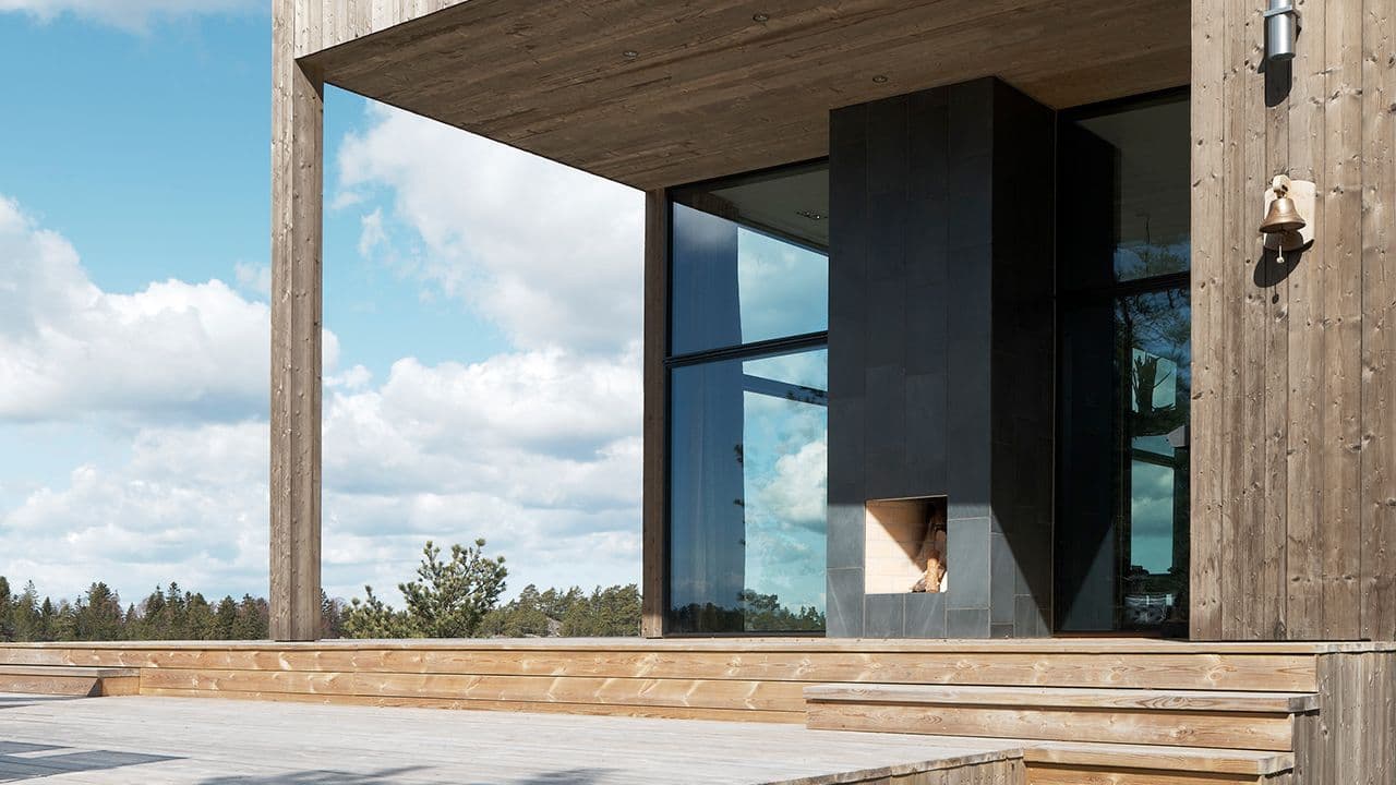 Store alukledde vinduer på moderne hus med stor utepeis.