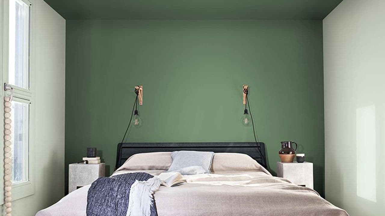 Soverom med dobbeltseng og grønne vegger og tak