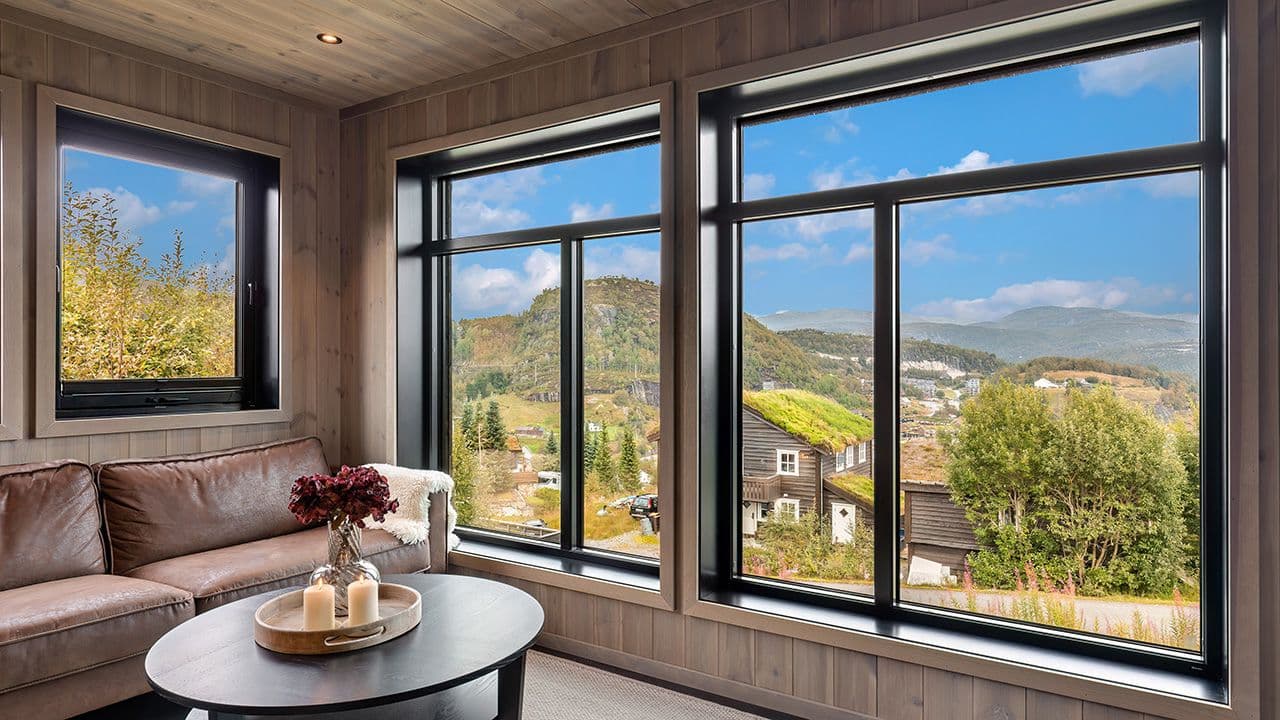 Stue med store vinduer som er innadslående.