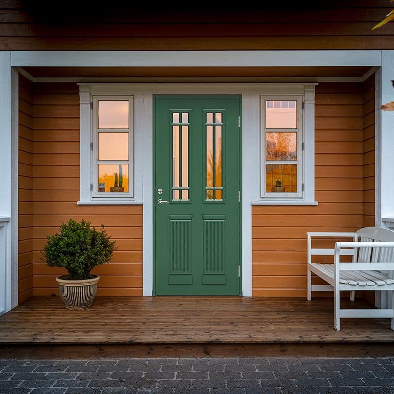 Grønn ytterdør fra Swedoor i et gult hus