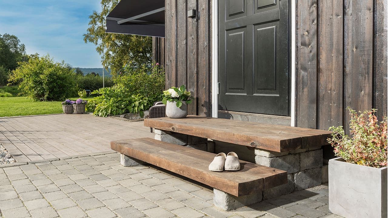 Trapp med jernbanesviller ved inngangsdør.