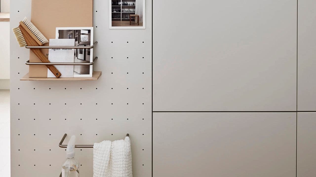 Dekorside på høyskap til opphenging av kjøkkenredskaper på hyttekjøkken.