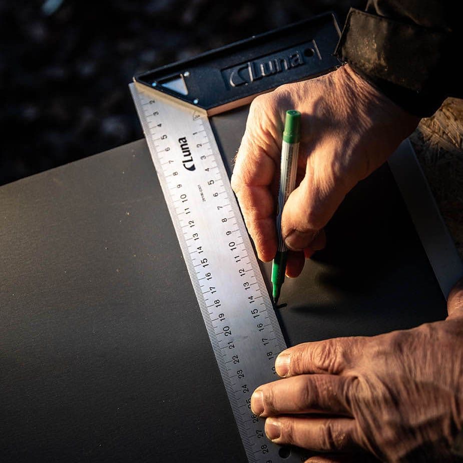 Snekker merker opp en plate med vinkeljern