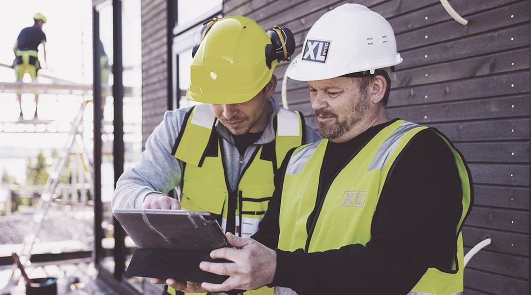 to håndverkere bestiller materialer med en ipad på byggeplassen