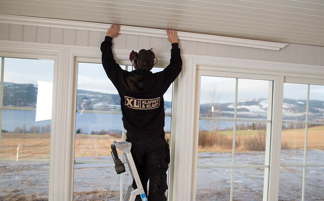 Håndverker som fester taklister.