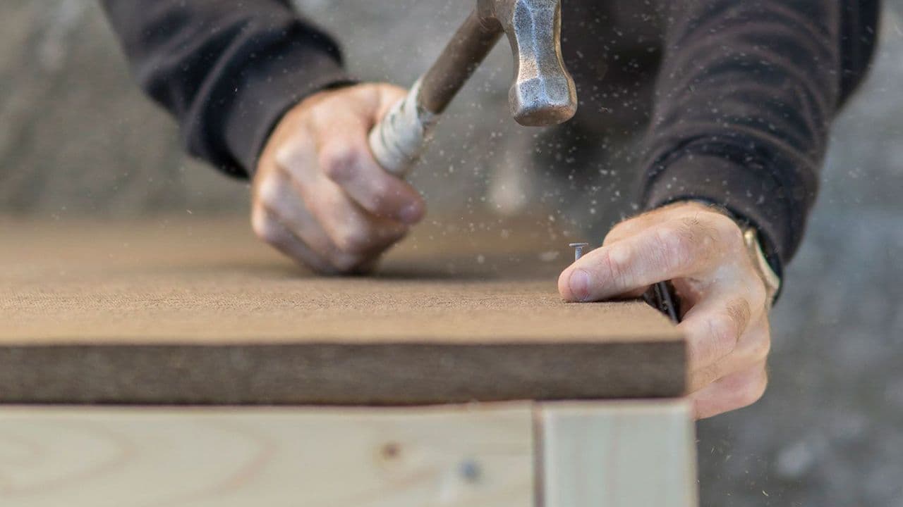 Person som gjør klar asfaltplater for montering.