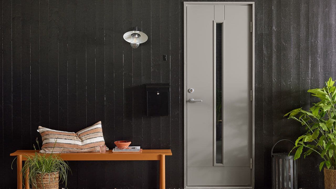 Husvegg malt med DRYGOLIN Nordic Extreme 0099 Sort og dør i 1376 Kontur.