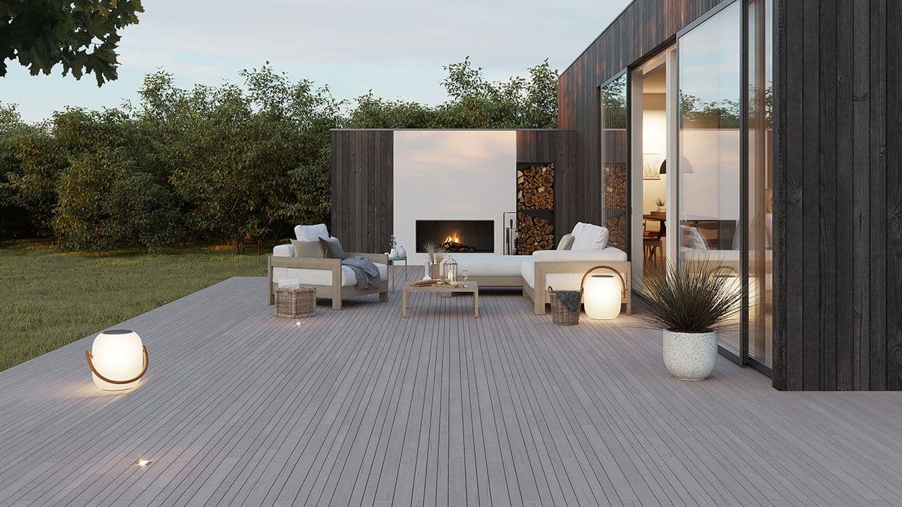 Moderne terrasse med lektegulv i grått med stemningslys og utemøbler.