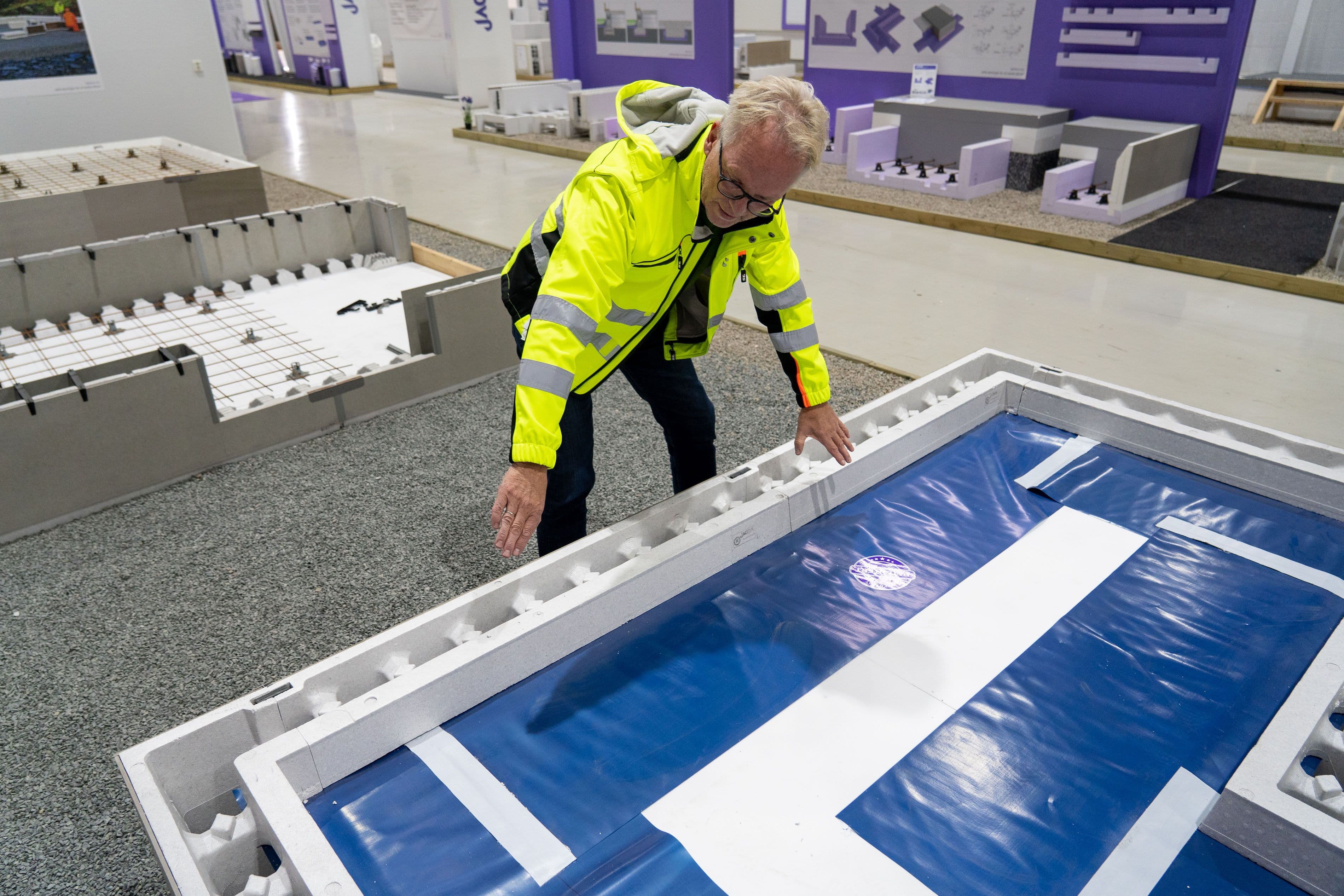 mann i gul jakke viser frem Jackon ringmur RA-blokk