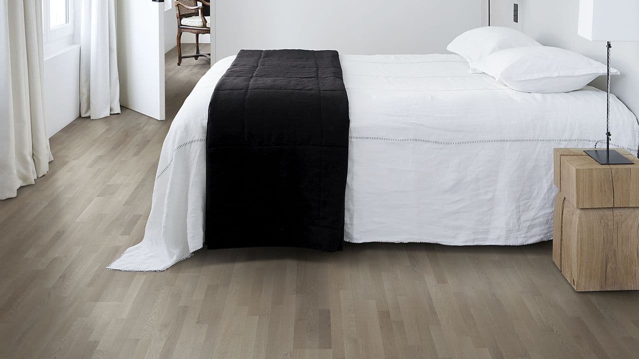 Hvitt soverom med mørke gulv som gir hotellfølelse på soverommet.