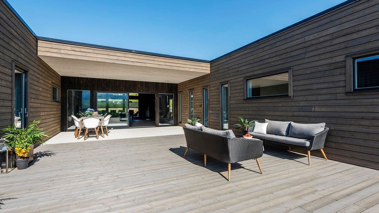 Stor terrasse med Concise terrassebord, sittegruppe med sofa og spiseplass.