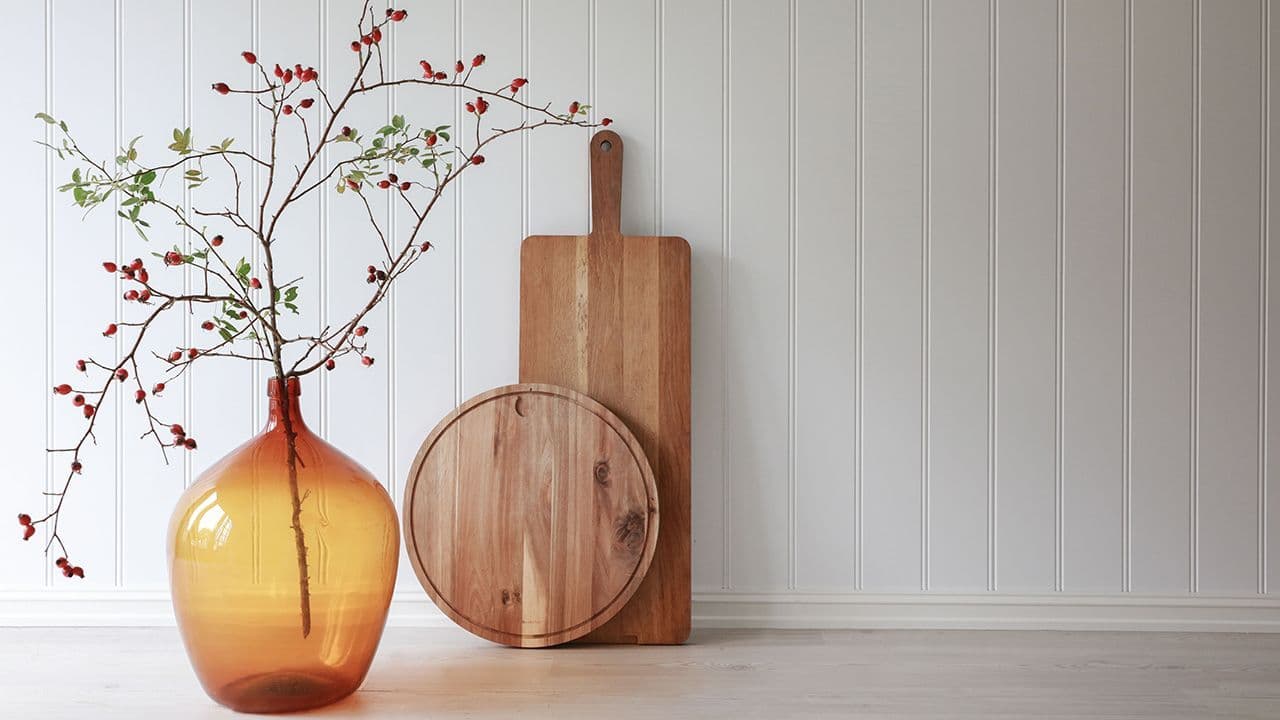 Bilde av vegg med fjøl og vase foran