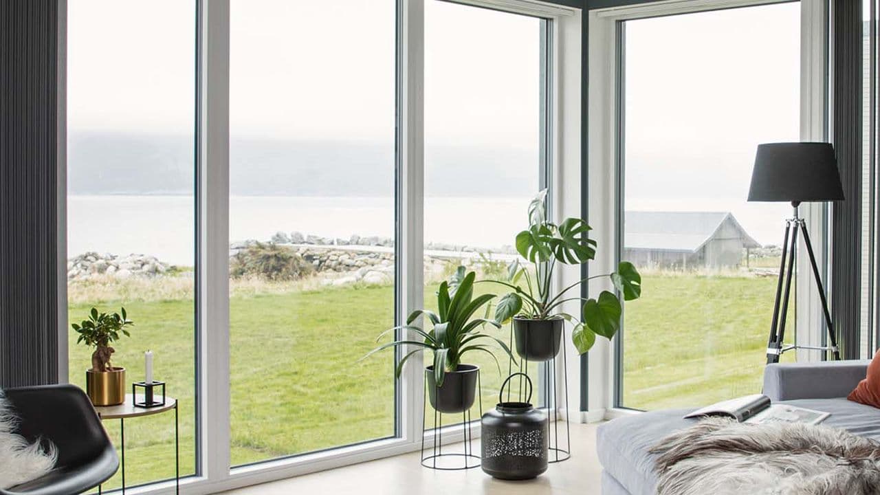 Store pvc-vinduer fra gulv til tak med utsikt mot havet.