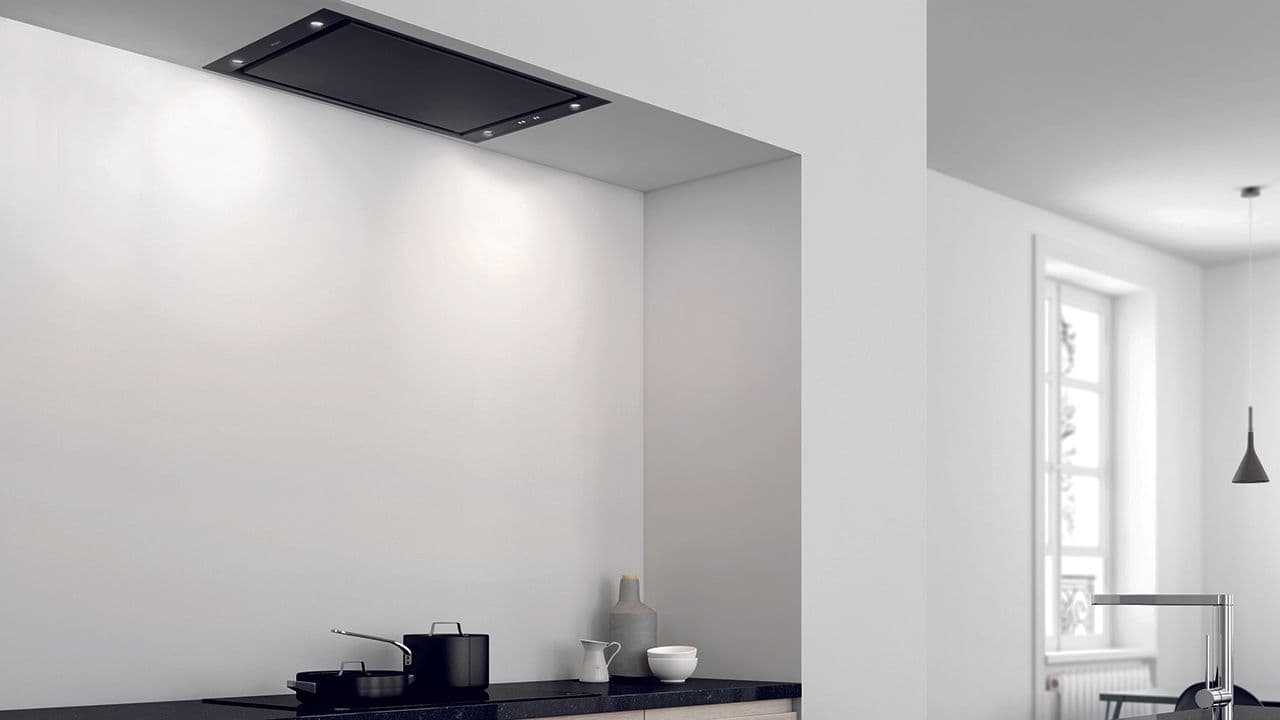 Svart takmontert kjøkkenvifte i hvitt kjøkken.