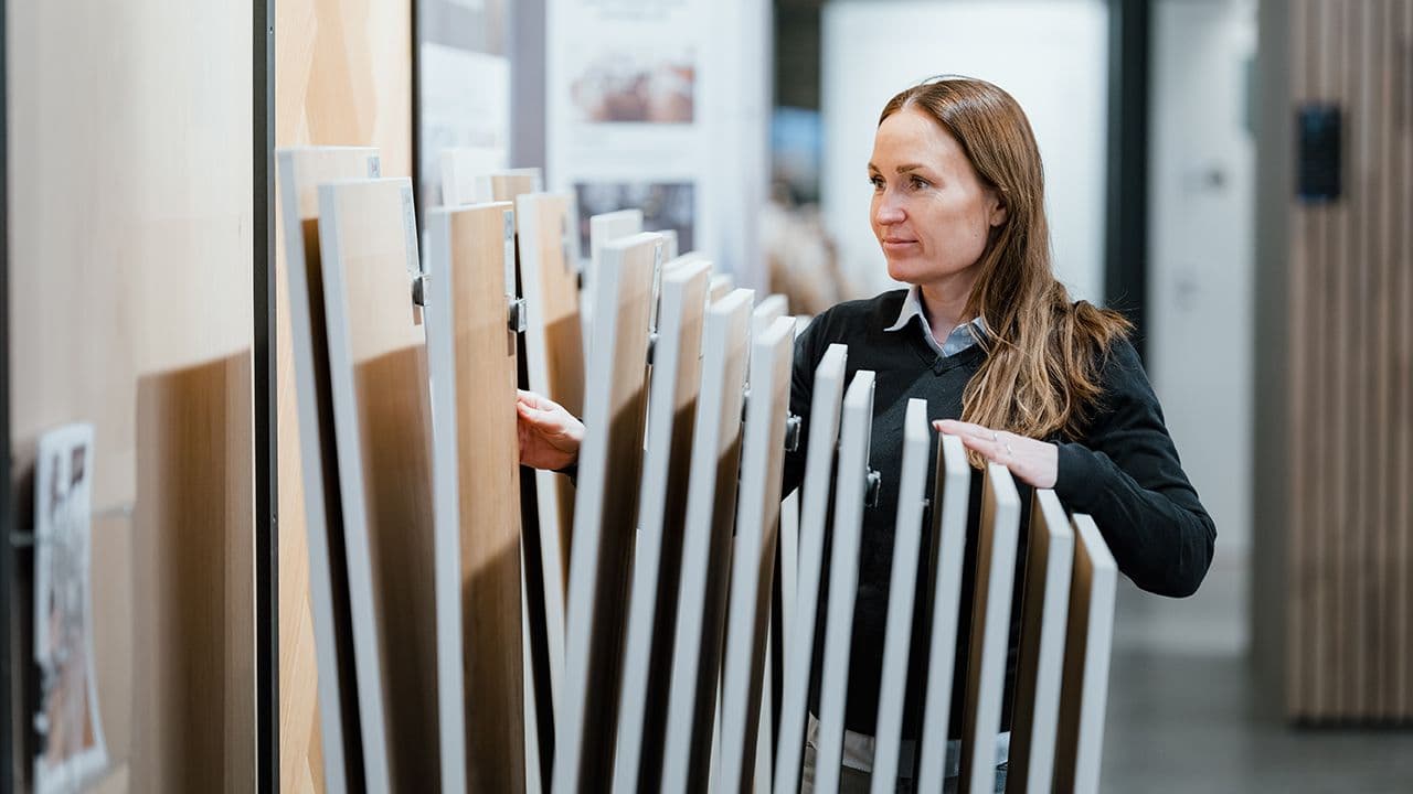 Ann-Charlott Nilsen ved XL-Bygg Tønsberg blar i gulvprøver.