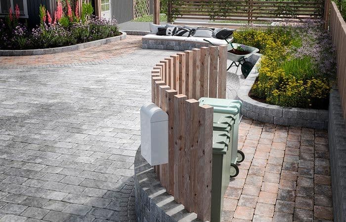 Innkjørsel av belegningsstein med poststativ i front.