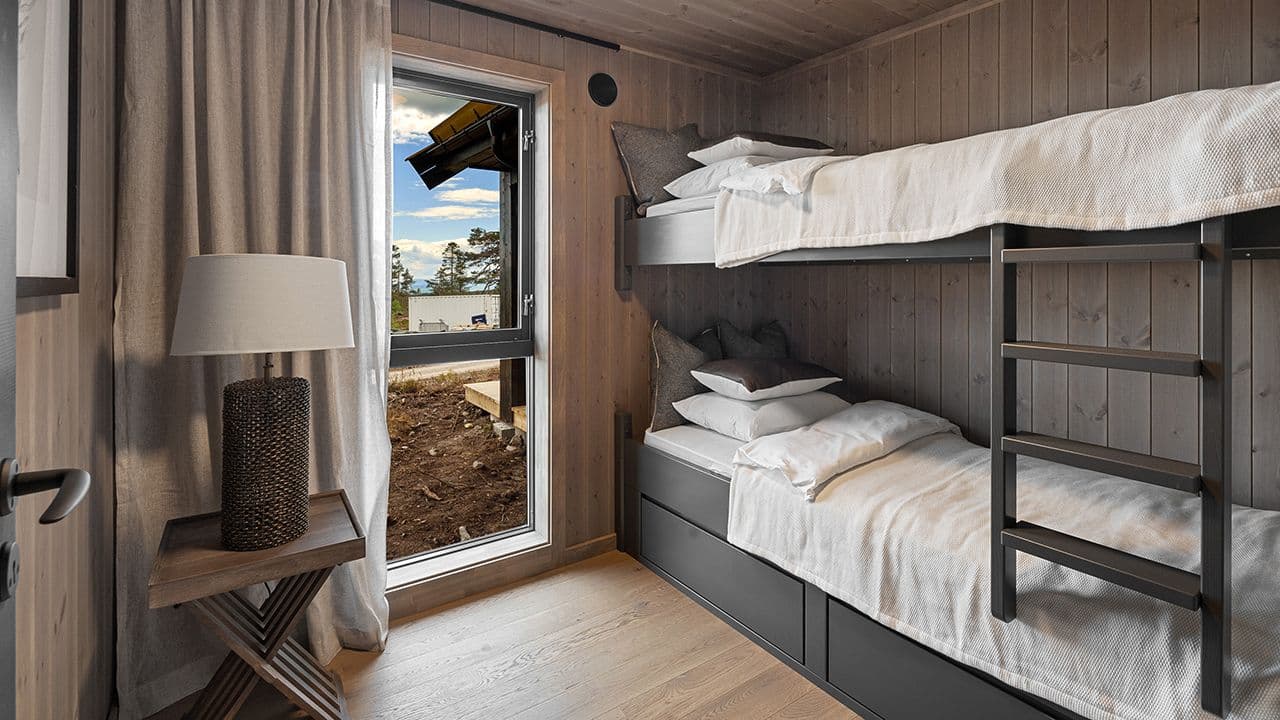 Hytte med store vindusflater på soverom med køyeseng.