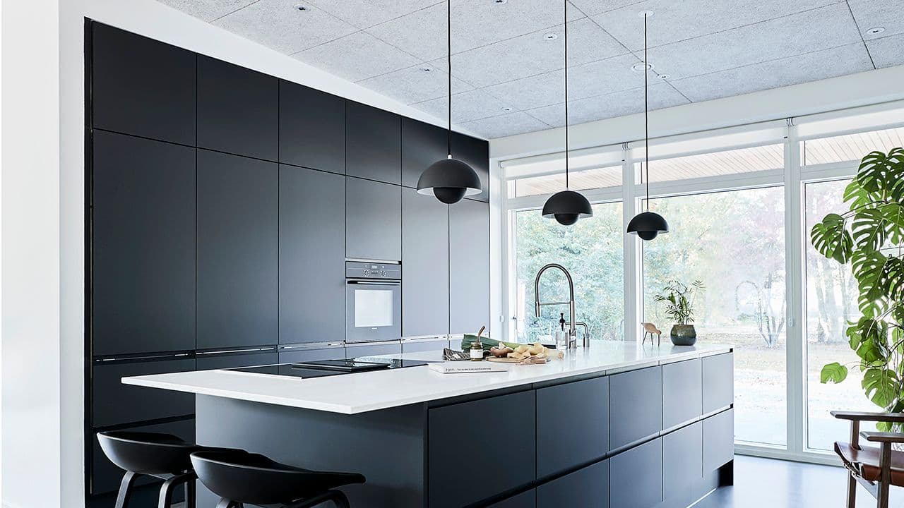 Grått kjøkken med høyskap til taket.