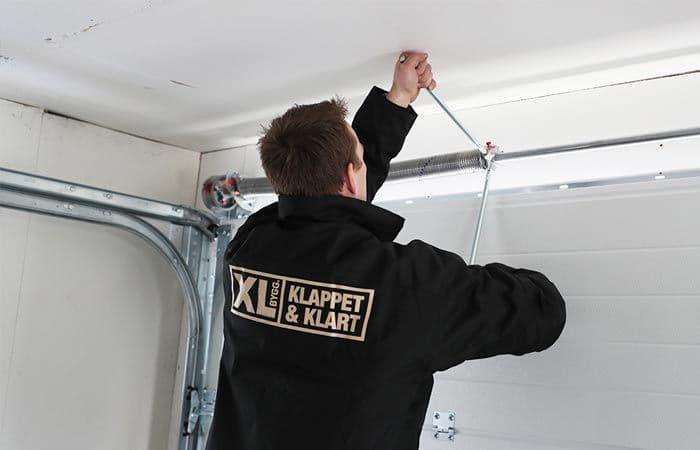 mann monterer en garasjeport