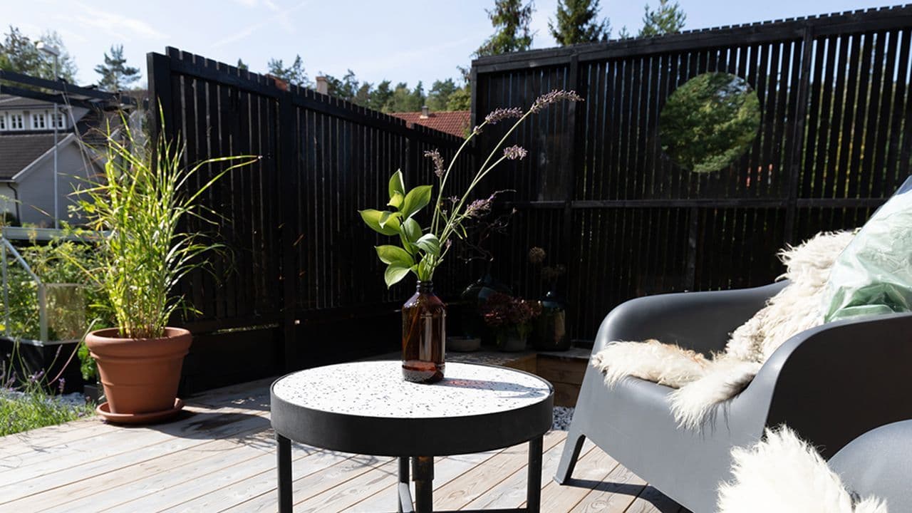 Sort levegg med spiler på terrasse.