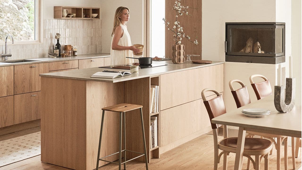 Kjøkken med åpen løsning til spisebord og peis.