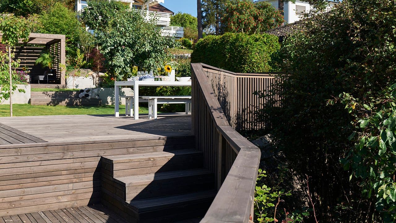 Opparbeidet hage med pene busker og trær. Terrasse, pergola, utetrapp og rekkverk bygget med Concise fra Talgø MøreRoyal.