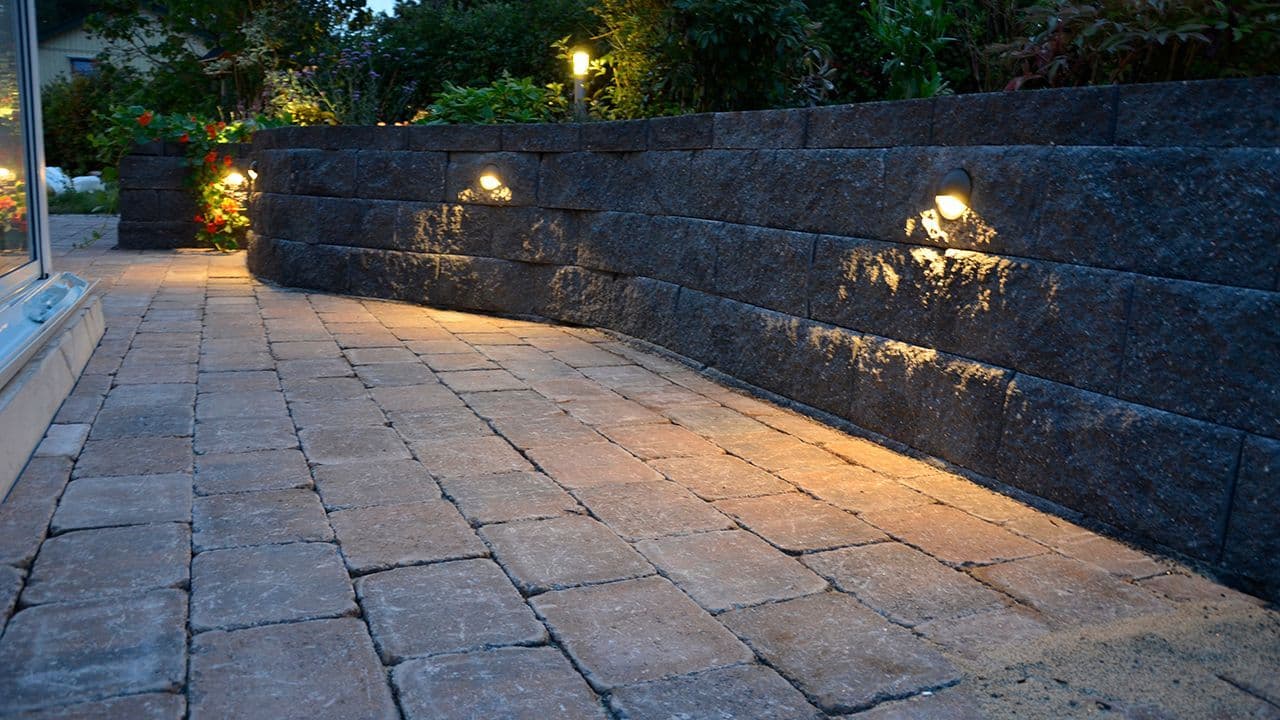 Asak Miljøstein innfelt utebelysning i støttemur i hage.