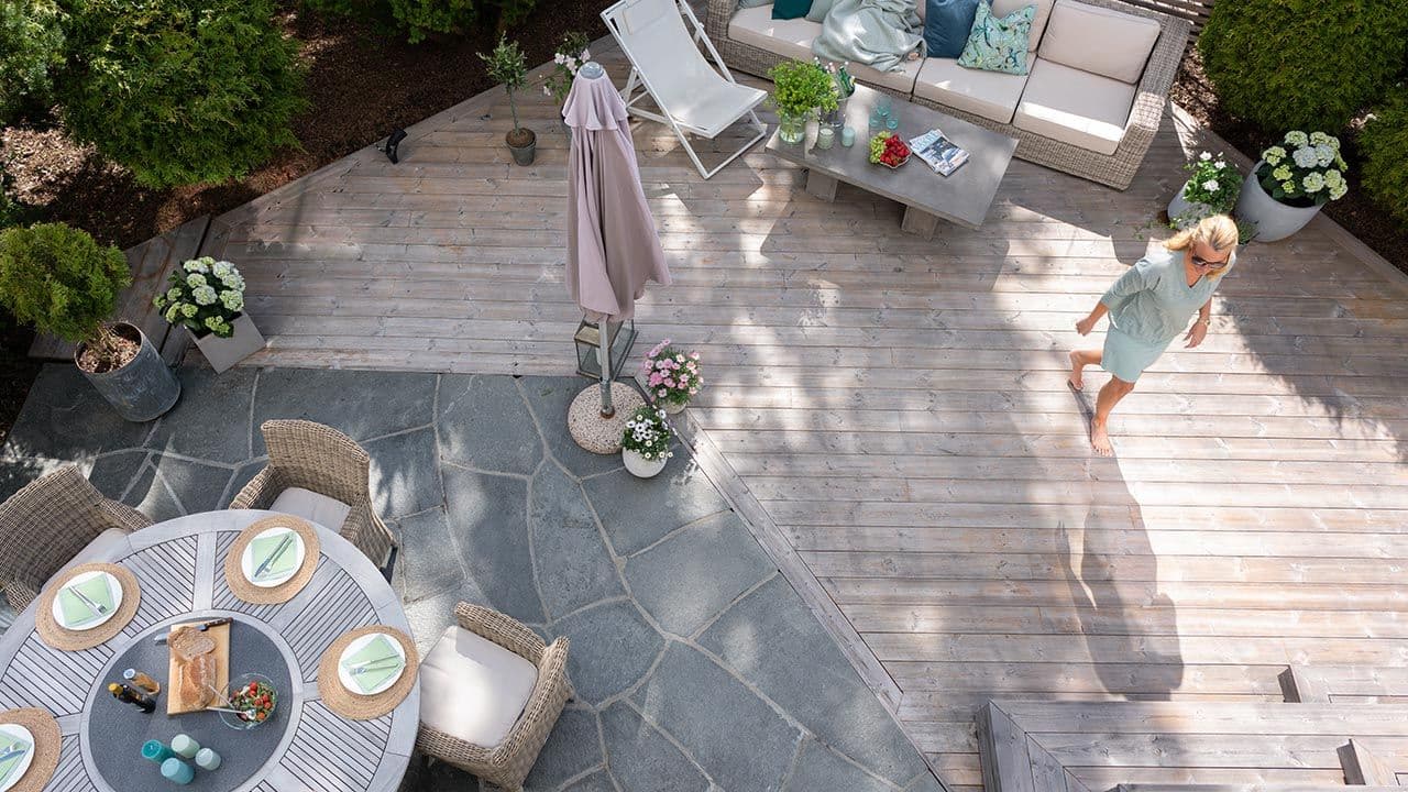 Sommerlig kledd kvinne som går over terrasse.